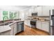 Modern kitchen featuring stainless steel appliances, white cabinets, and hardwood floors at 104 Edgewater Cir, Chapel Hill, NC 27516