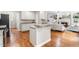 Bright kitchen with white cabinets, hardwood floors, and an open layout into the living area at 104 Edgewater Cir, Chapel Hill, NC 27516