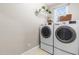 Convenient laundry room featuring a washer, dryer, storage shelf, and natural light from the window at 104 Edgewater Cir, Chapel Hill, NC 27516
