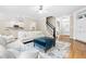 Inviting living room with hardwood floors, white sofas, and staircase access at 104 Edgewater Cir, Chapel Hill, NC 27516