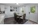 Bright dining room with view of kitchen, features dark floors, modern mirror decorations, and large window at 109 Gladstone Dr, Durham, NC 27703