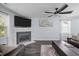 Living room view with dark floors, marble fireplace, large TV, ceiling fan, and large window at 109 Gladstone Dr, Durham, NC 27703