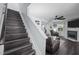 View of stairs leading to living room with wood floors, fireplace, ceiling fan, and ample natural light at 109 Gladstone Dr, Durham, NC 27703