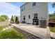 View of the home's concrete patio with a grill, bench, and a stone retaining wall at 109 Gladstone Dr, Durham, NC 27703