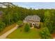 Aerial view of a brick home on a lush, green lawn surrounded by trees at 119 Eagles Watch Ln, Chapel Hill, NC 27517