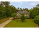 Aerial view of a brick home on a lush, green lawn surrounded by trees at 119 Eagles Watch Ln, Chapel Hill, NC 27517