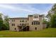 Exterior view of a spacious home with a large backyard, wooden deck, and ample windows for natural light, nestled among trees at 119 Eagles Watch Ln, Chapel Hill, NC 27517