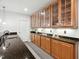 Close-up of a wet bar with stained cabinets, granite countertop and tile floors at 119 Eagles Watch Ln, Chapel Hill, NC 27517