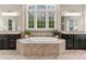 Bright bathroom featuring a large tub, tile surround, dual vanities, and a large window offering natural light and views at 119 Eagles Watch Ln, Chapel Hill, NC 27517