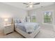 Bright bedroom with neutral tones, a ceiling fan, large windows, and plush bedding creating a relaxing atmosphere at 119 Eagles Watch Ln, Chapel Hill, NC 27517