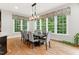 Bright dining room boasts natural light and views with a modern chandelier at 119 Eagles Watch Ln, Chapel Hill, NC 27517