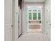 Hallway featuring a mirrored closet, leading to the bathroom with a large tub at 119 Eagles Watch Ln, Chapel Hill, NC 27517
