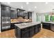 This spacious kitchen features dark wood cabinets, a brick backsplash, and a large center island at 119 Eagles Watch Ln, Chapel Hill, NC 27517
