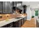 Close-up of kitchen featuring a gas cooktop, granite countertops, and dark wood cabinets at 119 Eagles Watch Ln, Chapel Hill, NC 27517