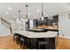 An expansive kitchen showcases bar seating at a huge island with granite countertops and stainless appliances at 119 Eagles Watch Ln, Chapel Hill, NC 27517