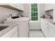 Bright laundry room boasts white cabinets, granite countertops and stainless sink at 119 Eagles Watch Ln, Chapel Hill, NC 27517
