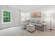 Comfortable living room with a gray couch, two ottomans, and a large picture window at 119 Eagles Watch Ln, Chapel Hill, NC 27517
