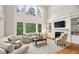 Spacious living room with soaring ceilings, large windows, and a cozy fireplace at 119 Eagles Watch Ln, Chapel Hill, NC 27517