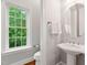 Charming powder room with pedestal sink and a window offering a view of lush greenery at 119 Eagles Watch Ln, Chapel Hill, NC 27517