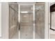 Modern tiled shower with glass enclosure, rainfall showerhead, bench, and built-in shelving for a luxurious experience at 119 Eagles Watch Ln, Chapel Hill, NC 27517