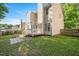View of the home's back exterior overlooking a well-kept lawn with a deck and stone patio at 121 River Hills Dr, Clayton, NC 27527