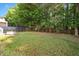 Expansive backyard featuring lush greenery, a trampoline, and bordered by a wooden fence and mature trees at 121 River Hills Dr, Clayton, NC 27527