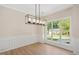 Elegant dining room featuring stylish flooring, modern light fixture, and large window at 121 River Hills Dr, Clayton, NC 27527