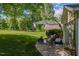 Backyard with a stone patio, seating, and mature trees at 121 Walter Hagen Dr, Mebane, NC 27302