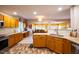 Bright eat-in kitchen featuring wood cabinets, brick floors, and updated appliances at 121 Walter Hagen Dr, Mebane, NC 27302