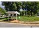 Community mailboxes nestled in a grassy area with mature trees, sidewalks, and well-maintained landscaping at 121 Walter Hagen Dr, Mebane, NC 27302
