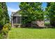 A screen porch in a backyard featuring a well-maintained lawn and mature trees at 1218 Crystalwater Dr, Fuquay Varina, NC 27526
