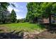 Expansive backyard featuring a well-maintained lawn and mature trees, creating a serene outdoor space at 1218 Crystalwater Dr, Fuquay Varina, NC 27526