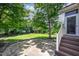 Secluded backyard features a stone patio surrounded by lush landscaping and mature trees at 1218 Crystalwater Dr, Fuquay Varina, NC 27526