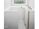Clean, bright accessible bathroom features a walk-in tub and translucent window above at 1218 Crystalwater Dr, Fuquay Varina, NC 27526