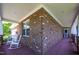 Long covered porch with white rocking chairs, wood floors, and a brick exterior at 1218 Crystalwater Dr, Fuquay Varina, NC 27526