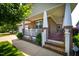 Inviting covered porch with brick steps, white railing and columns, and a cozy seating area at 1218 Crystalwater Dr, Fuquay Varina, NC 27526