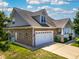 A two-story home with brick and shingle siding with an attached two car garage and manicured lawn at 1218 Crystalwater Dr, Fuquay Varina, NC 27526