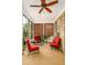 Inviting screened porch features brick accents, a ceiling fan, and cozy red furniture for relaxing at 1218 Crystalwater Dr, Fuquay Varina, NC 27526
