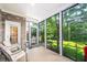 Cozy screened porch with brick accents, comfortable seating, and views of the lush backyard at 1218 Crystalwater Dr, Fuquay Varina, NC 27526