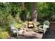 Backyard scene features outdoor seating around a stone fire pit with stacked logs at 126 Barclay Rd, Chapel Hill, NC 27516