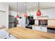 Bright and airy kitchen boasts white cabinets, butcher block countertops, stainless steel appliances, and stylish lighting at 126 Barclay Rd, Chapel Hill, NC 27516