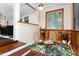 Cozy sitting room with wood walls, leafy rug, comfortable chairs, and ample natural light creating a warm, inviting space at 126 Barclay Rd, Chapel Hill, NC 27516