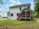 Backyard view of the house with a screened-in porch and lawn at 1338 The Parks Dr, Pittsboro, NC 27312