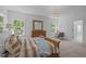 Bedroom with large windows, and stylish furnishings including a dresser and side tables at 1338 The Parks Dr, Pittsboro, NC 27312