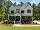 Stunning two-story home with a combination of stone and white wood and a welcoming front porch at 1338 The Parks Dr, Pittsboro, NC 27312