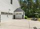 Three-car garage with an adjacent outdoor sitting area at 1338 The Parks Dr, Pittsboro, NC 27312