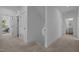 Bright hallway with carpet, white trim, doors, leading to bathroom and living space at 1338 The Parks Dr, Pittsboro, NC 27312