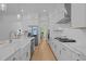 Extended view of an airy kitchen featuring white cabinets, stainless steel appliances, and an island at 1338 The Parks Dr, Pittsboro, NC 27312