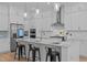 Bright, modern kitchen with white cabinetry, stainless steel appliances, and an island with seating at 1338 The Parks Dr, Pittsboro, NC 27312