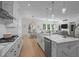 Open-concept kitchen featuring an island, white cabinets and seamless flow to living and dining at 1338 The Parks Dr, Pittsboro, NC 27312